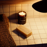 Lifestyle image of Earl of East Shinrin-Yoku Cleansing Soap Bar in a bathroom setting, with the Shinrin-Yoku candle demonstrating its use in a daily cleansing routine.