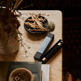 Shinrin-Yoku incense sticks burning in a modern living room setting with natural lighting