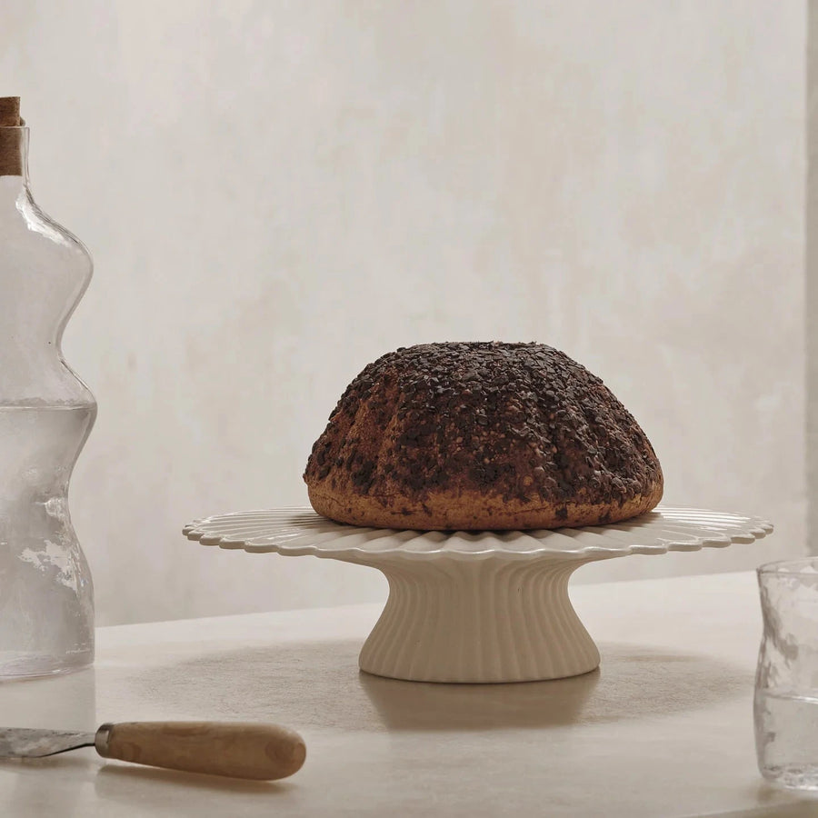 Fountain Cake Stand, Off White by ferm LIVING, holding a bundt cake