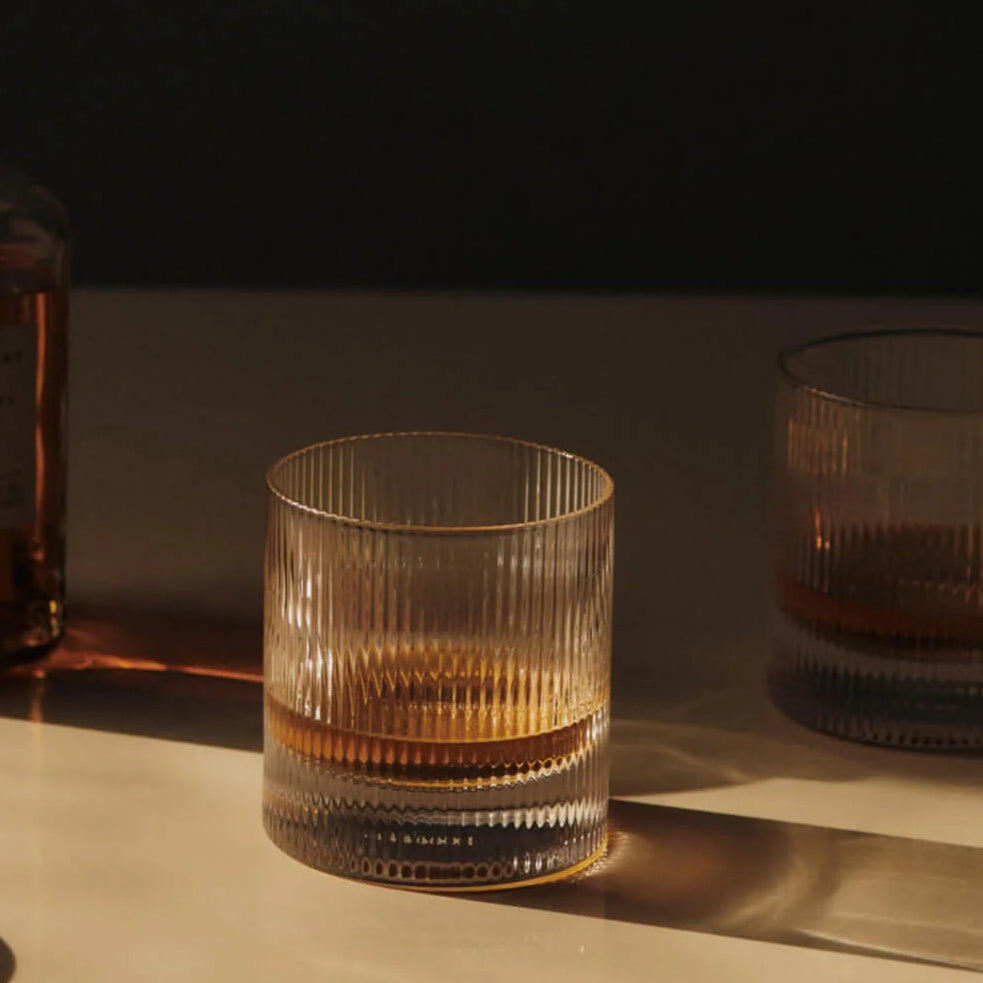 Ripple Tumbler Glasses, Set of 2 by ferm LIVING, holding whisky in warm light