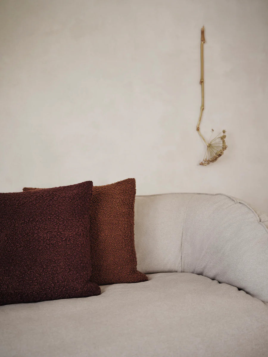 Moor Cushion, Dark Pecan by ferm LIVING, on a cream sofa