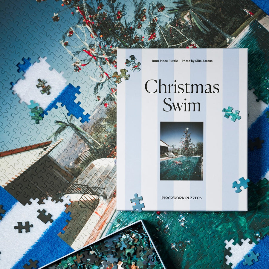 Christmas Swim jigsaw puzzle box with scattered pieces