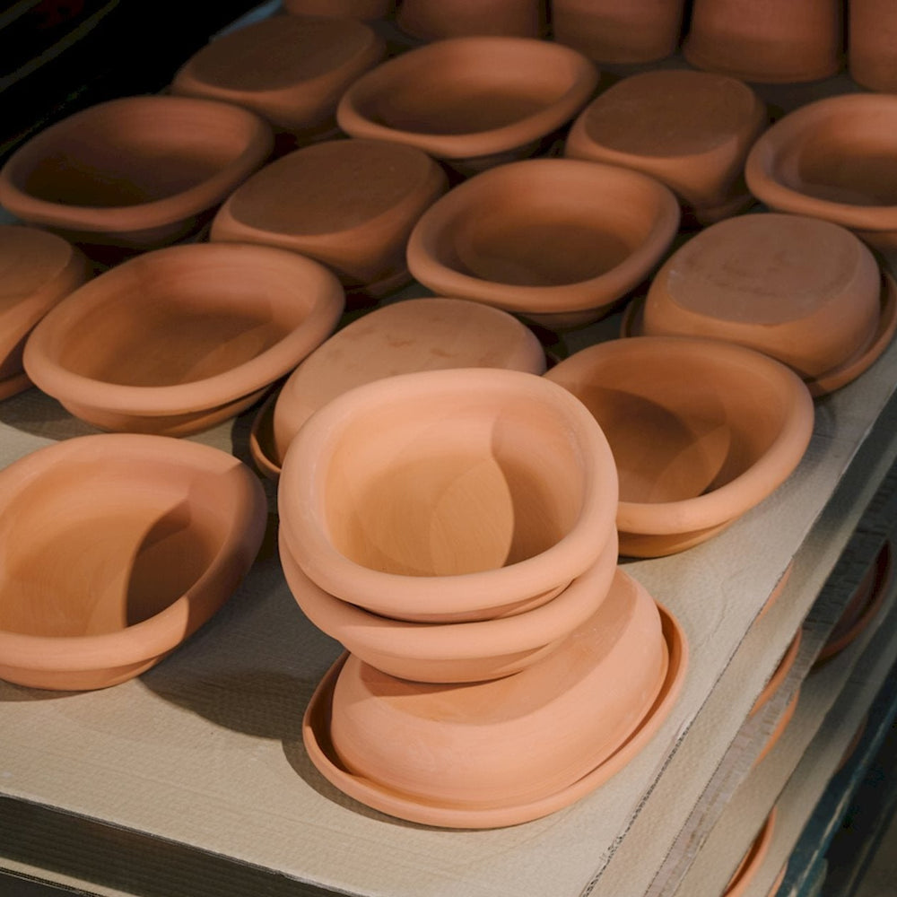 Barro Oval Dish, Large, Green by HAY, stacked with terracotta dishes