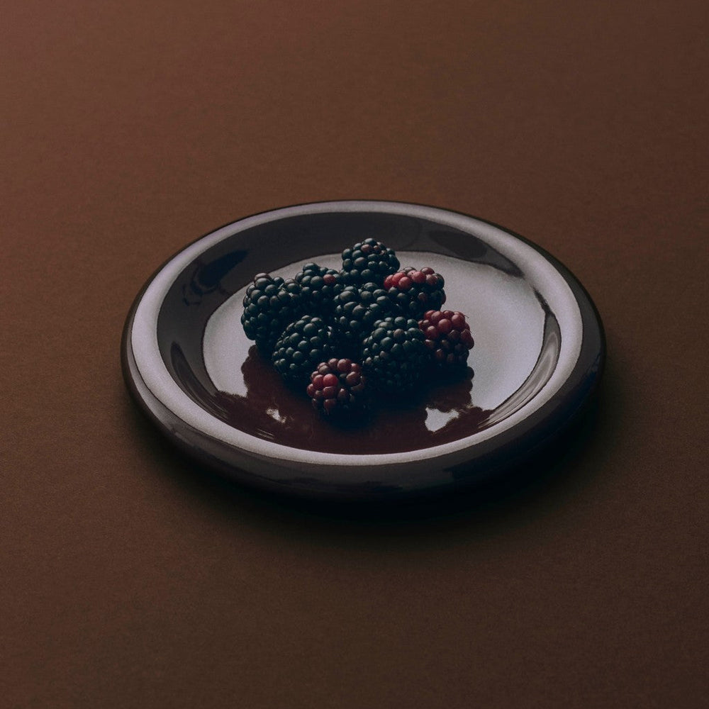 Barro Plate Set of Two, Ø18, Burgundy by HAY, holding blackberries on a dark background