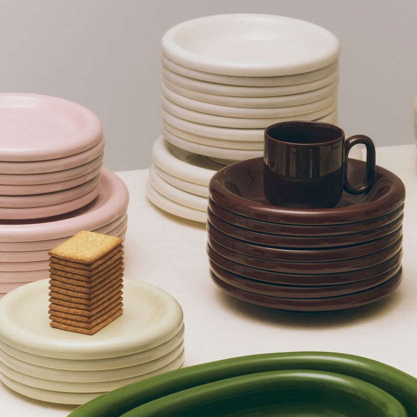 Barro Cup Set of Two, Burgundy by HAY, stacked with plates on white