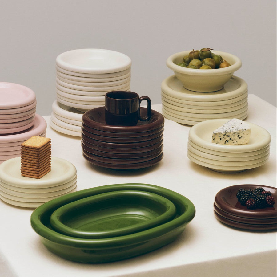 Barro Bowl, Set of Two, Pistachio by HAY, stacked with plates and an oval dish
