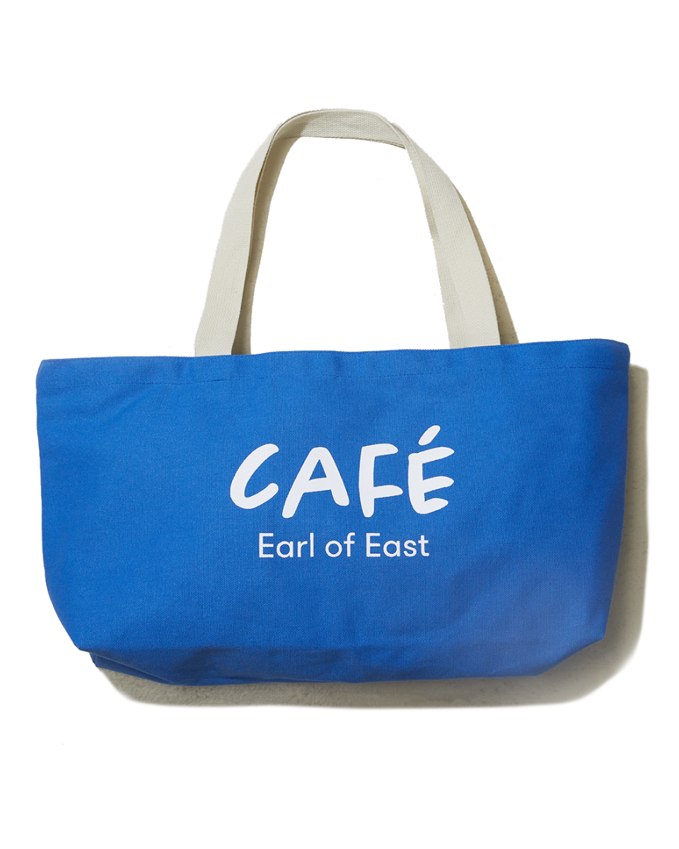 A blue cotton canvas market bag with cream handles and the text 'CAFÉ Earl of East' printed on the side.