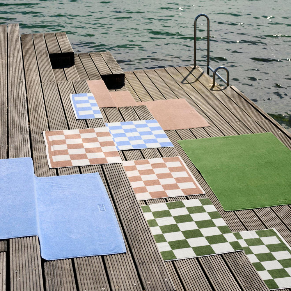 Mono Wash Cloth, Cappuccino by HAY, laid out on a wooden jetty