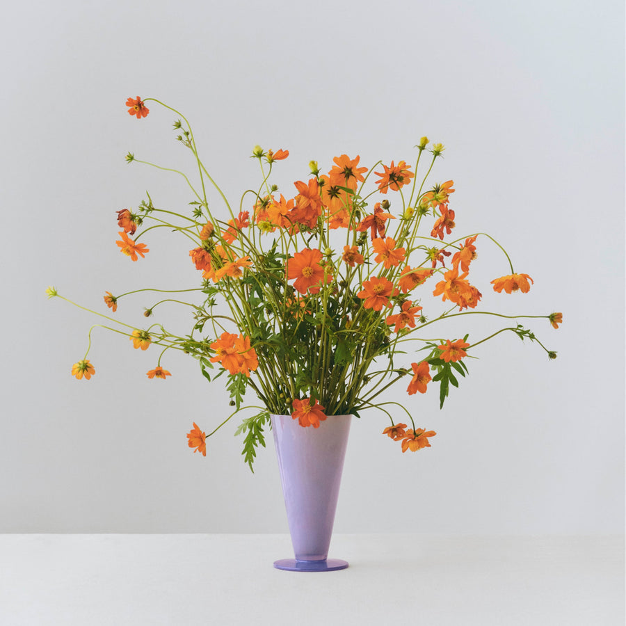 Conical Vase, Small, Light Blue & Lavender by HAY, holding orange wildflowers