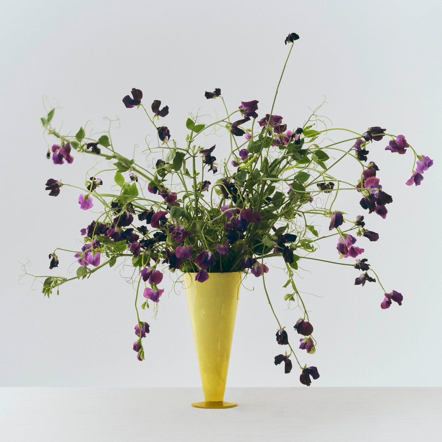 Conical Vase, Large, Yellow by HAY, holding purple wildflowers