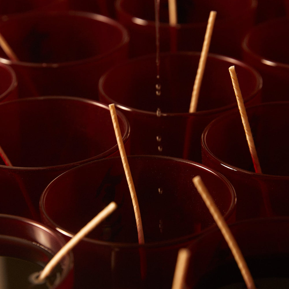 Eat Bitter Book & Bone Broth Candle Set by Earl of East, candles in red vessels being poured