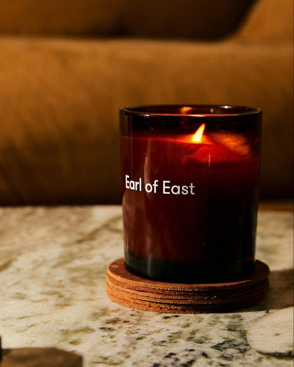 Smoke & Musk Scented Candle, 260ml by Earl of East, lit on a stone table