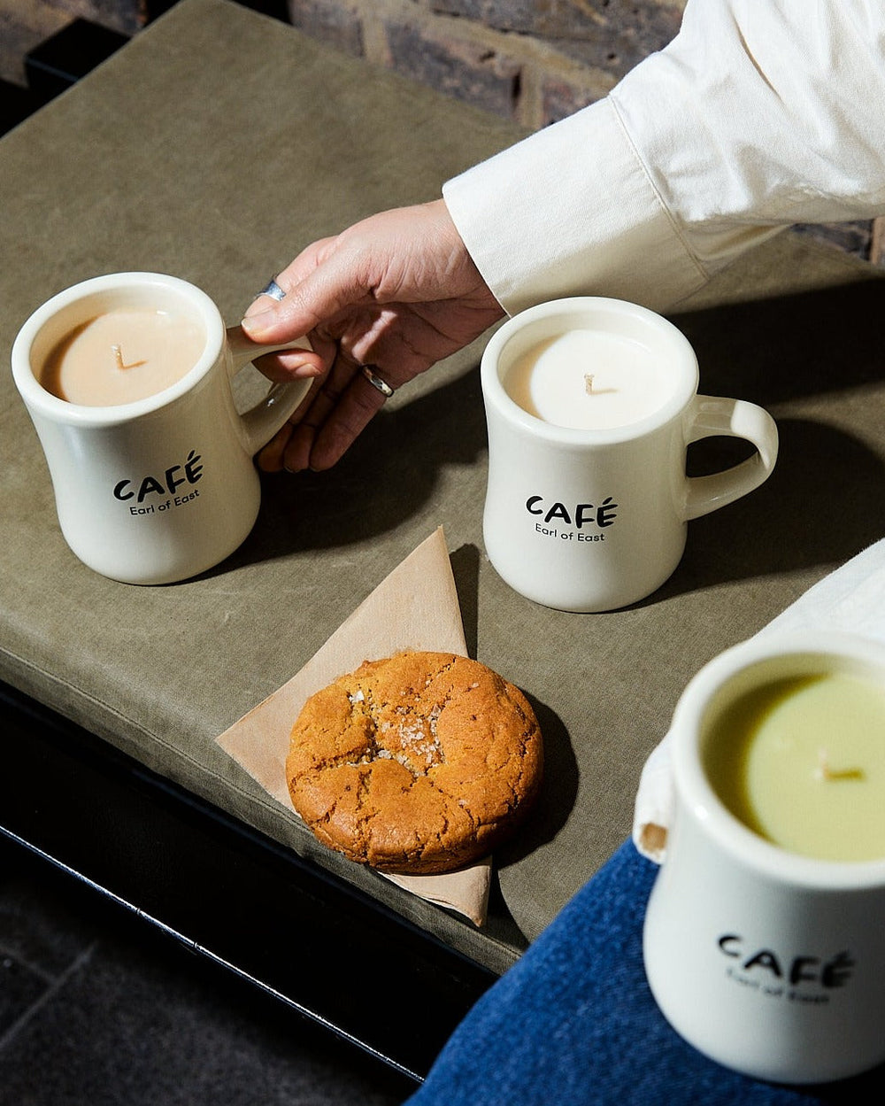 Iced Matcha Scented Candle in Mug, 300ml by Earl of East, on a café table with a pastry