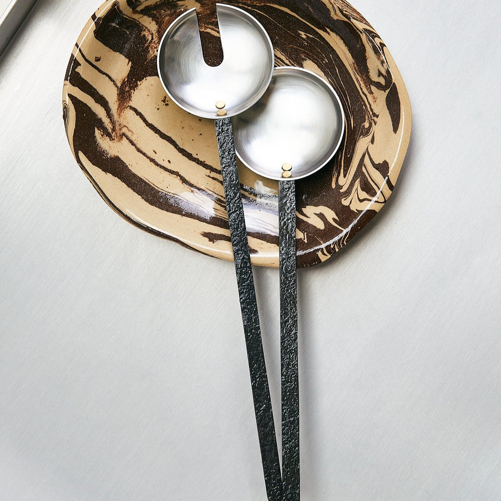 Obra Salad Servers, Stainless Steel by ferm LIVING, on a gold metallic surface