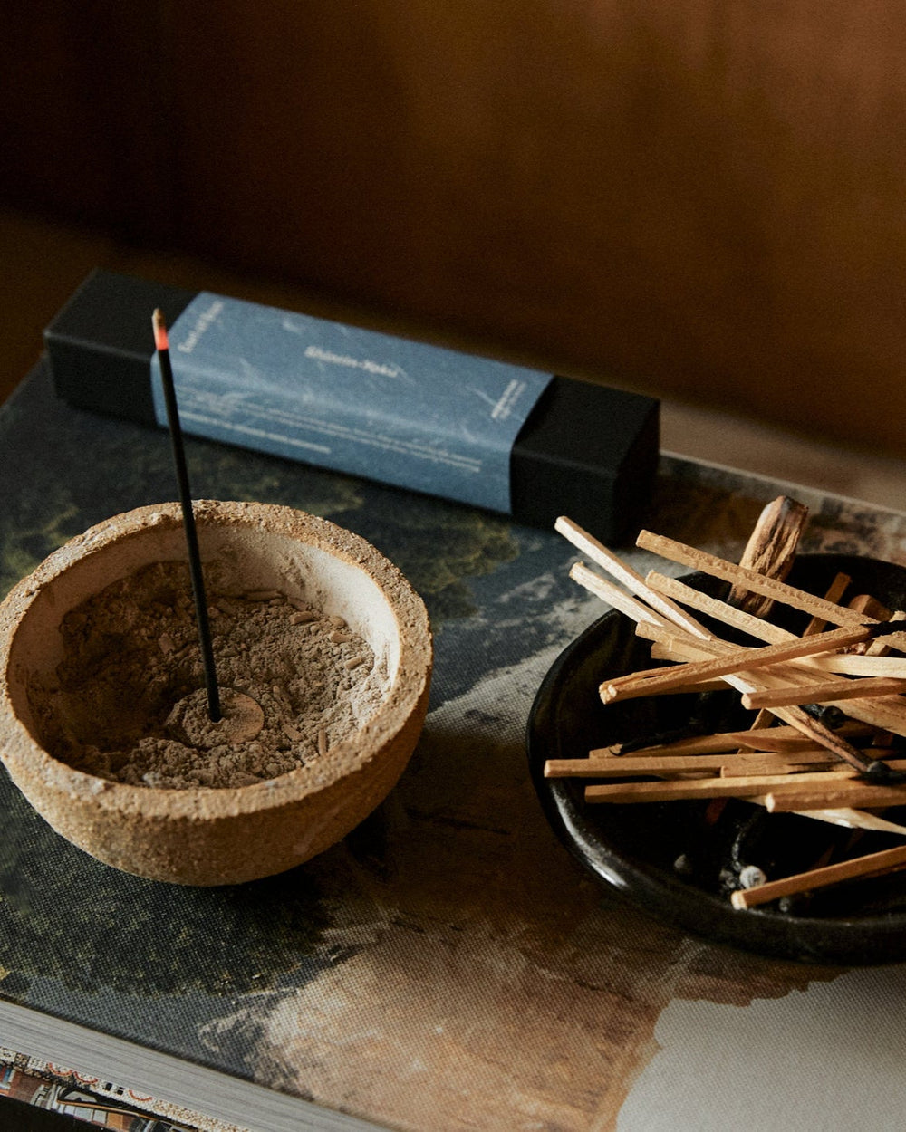 Close-up of lit Shinrin-Yoku incense stick creating aromatic smoke in a serene indoor environment
