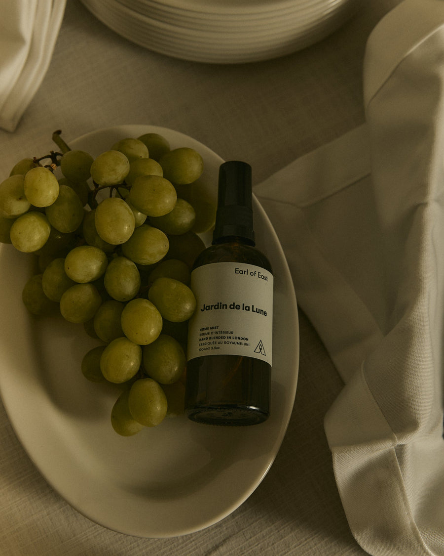 Jardin de la Lune Home Mist, 100ml by Earl of East, beside a bowl of olives