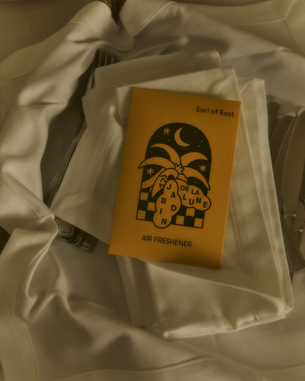 Jardin de la Lune Air Freshener by Earl of East, in its envelope on linen