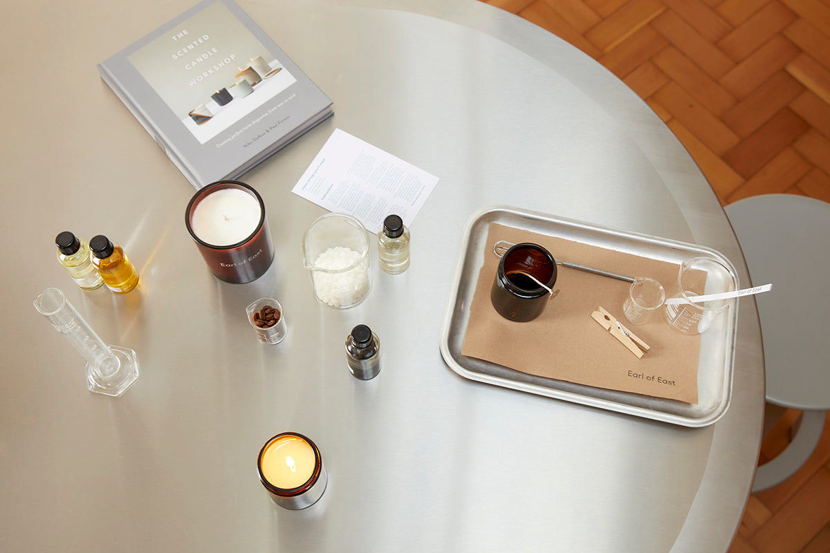  Candle making workshop table from above with glass jars and fragrance 
