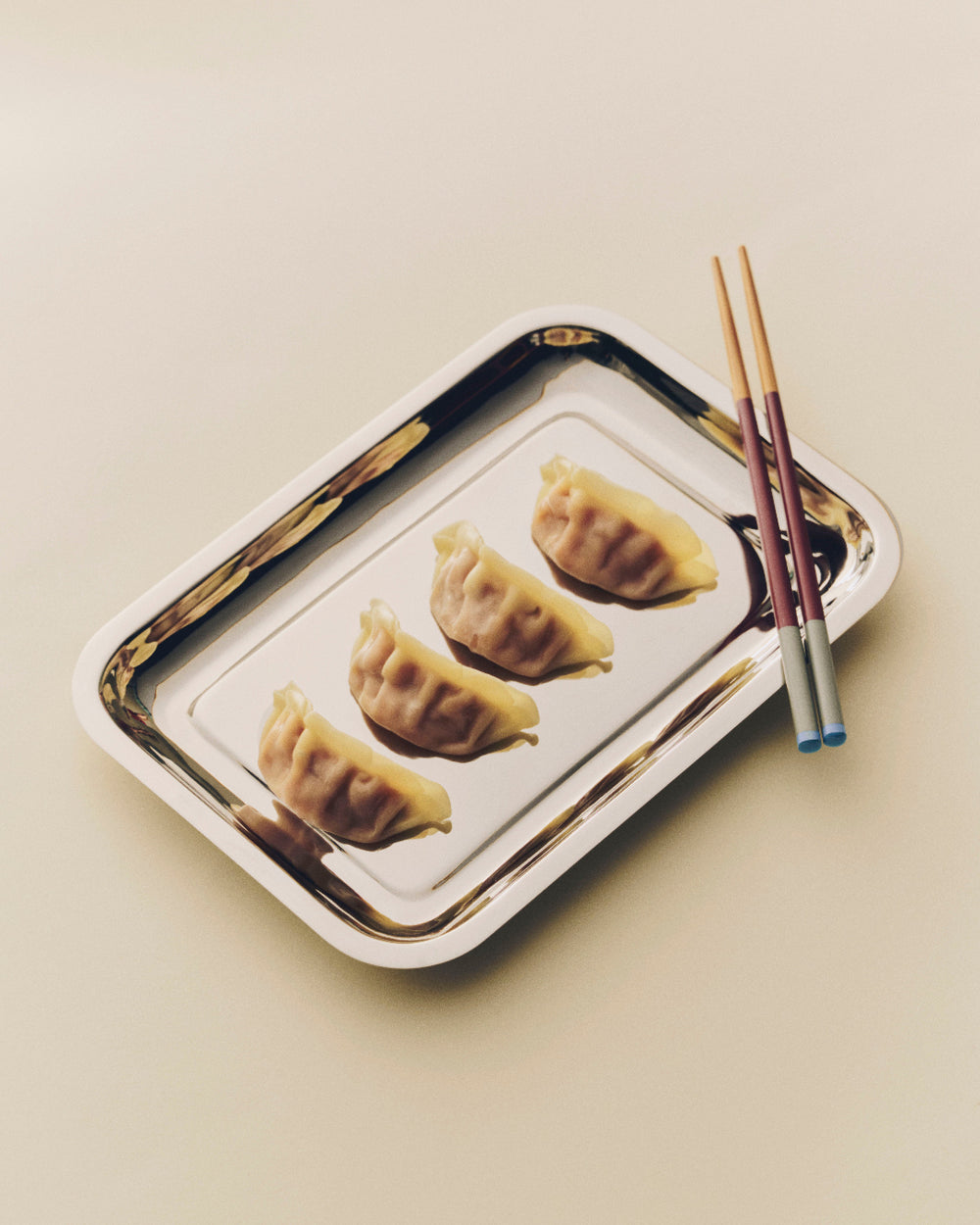 Colour Sticks Set of 4, Subtle by HAY, on a metal tray with dumplings