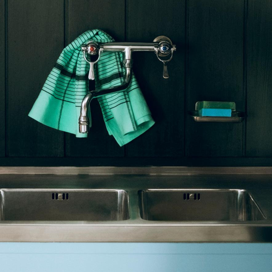 Linear Tea Towel, Green by HAY, hanging on a kitchen rail