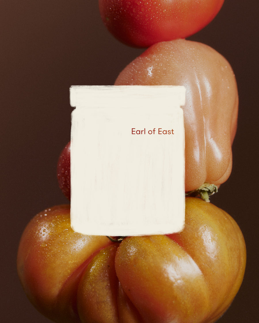 Greenhouse Scented Candle, 170ml by Earl of East, against stacked heirloom tomatoes