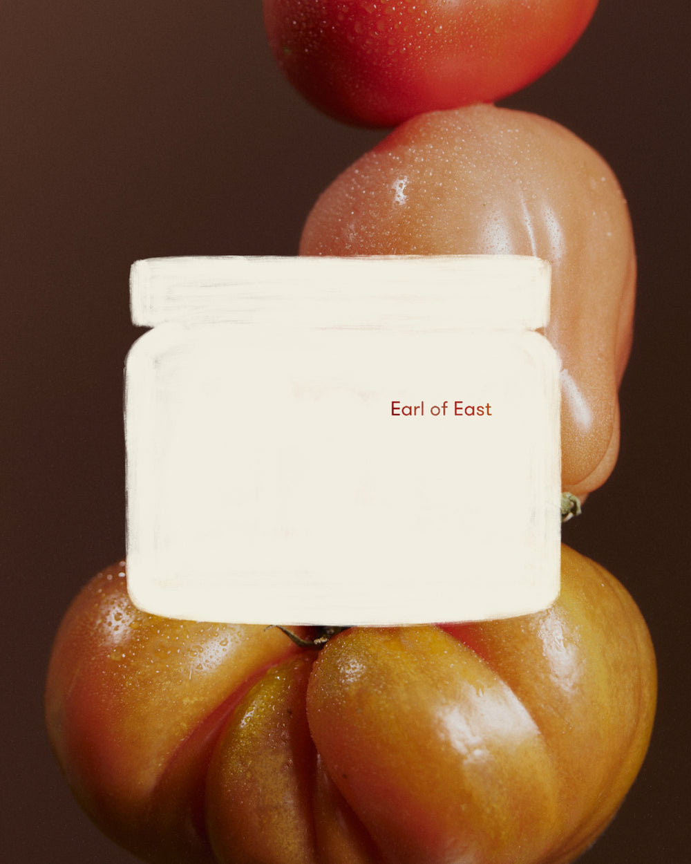 Greenhouse Large Scented Candle, 500ml by Earl of East, against stacked heirloom tomatoes