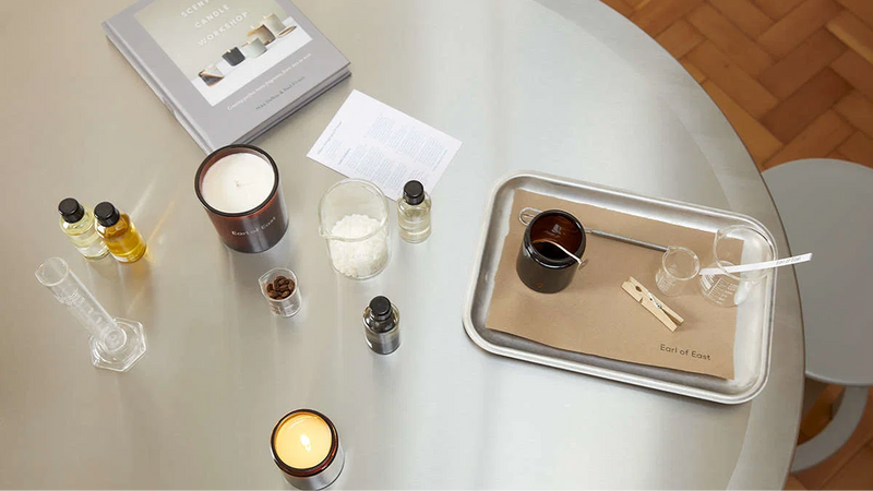 Candle making workshop table from above with glass jars and fragrance