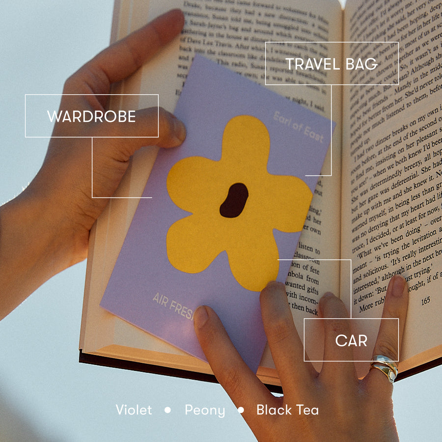 Flower Power, Air Freshener by Earl of East, hanging in front of an open book