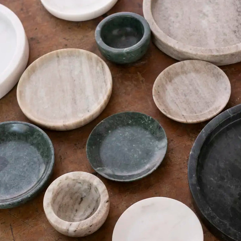 Handmade ceramic dishes in grey and green glazes on wood