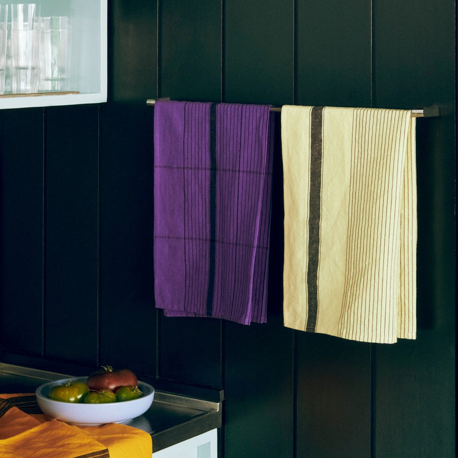 Linear Tea Towel, Soft Yellow by HAY, hanging on a rail in a range of colours
