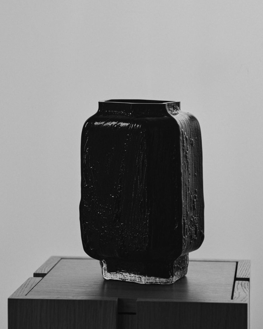 Mokuri Vase, Large, Black by ferm LIVING, on a dark plinth
