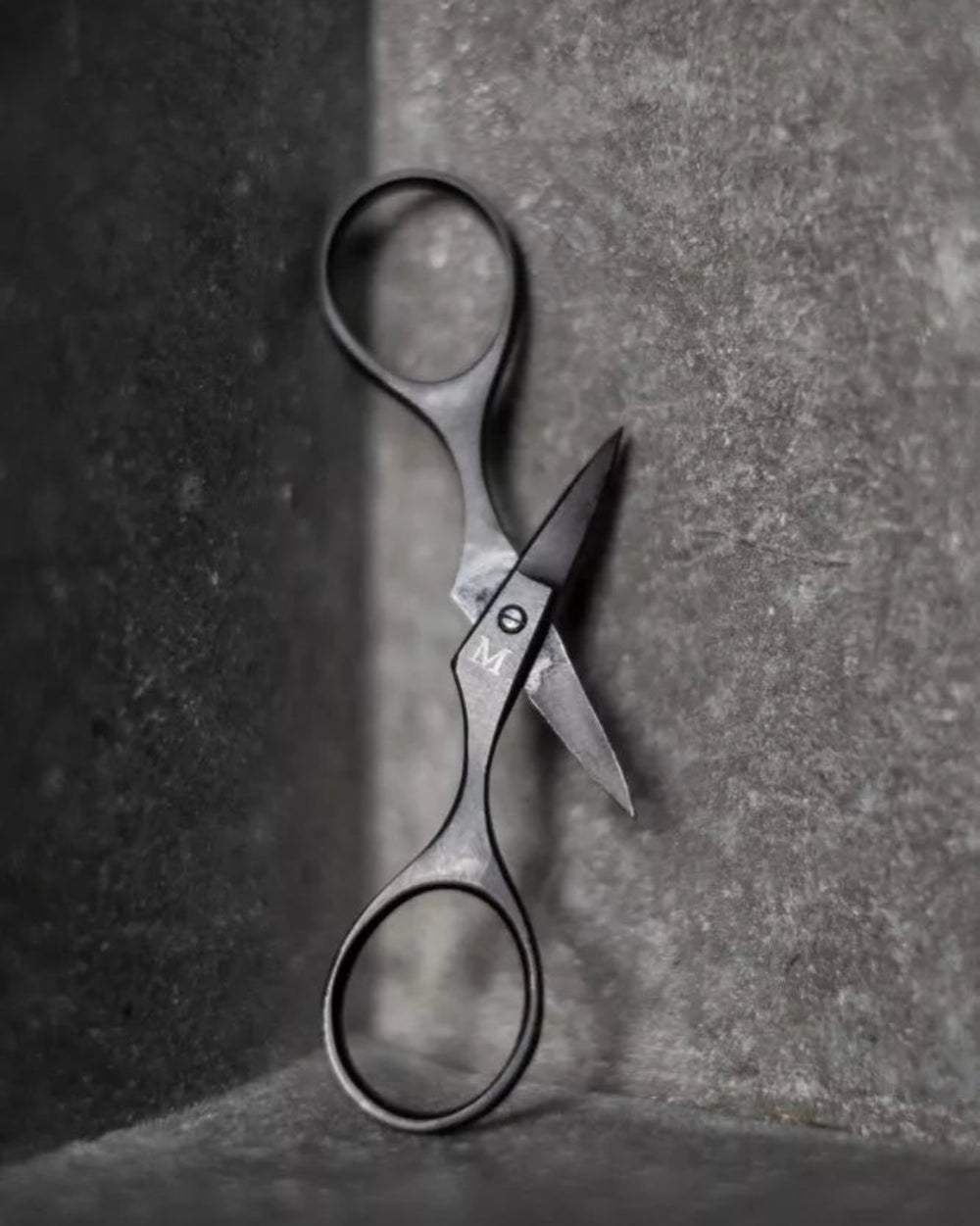Baby Bow Scissors by Merchant and Mills, hanging on a grey background