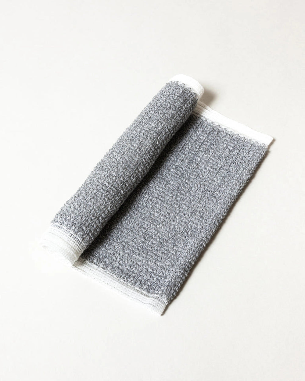 Binchotan Charcoal Body Scrub Towel by Morihata, rolled on white