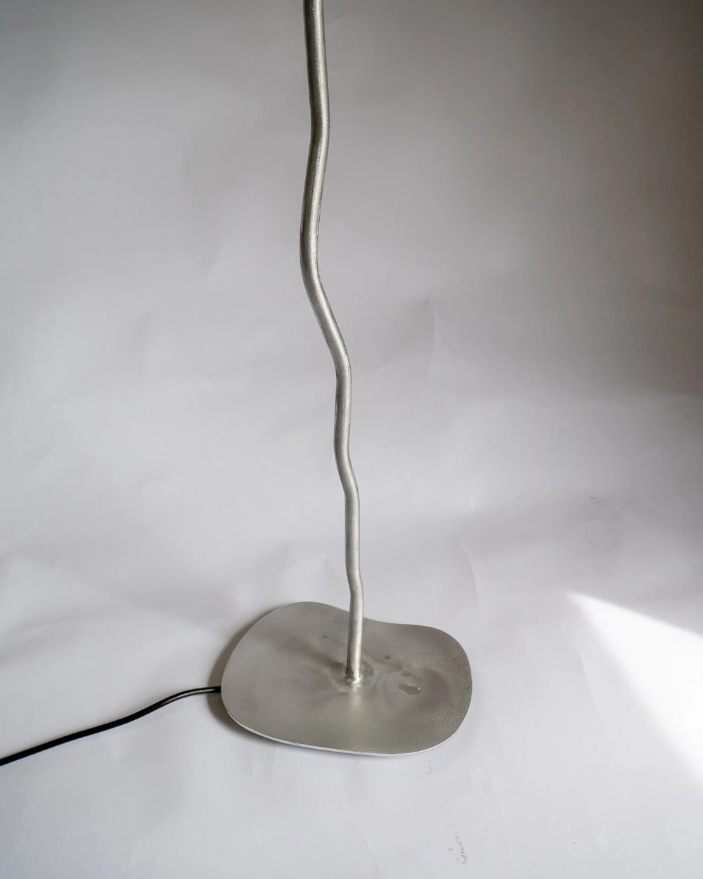 Pea Head Lamp, Aluminium by Six Dots Design, lit on a grey background