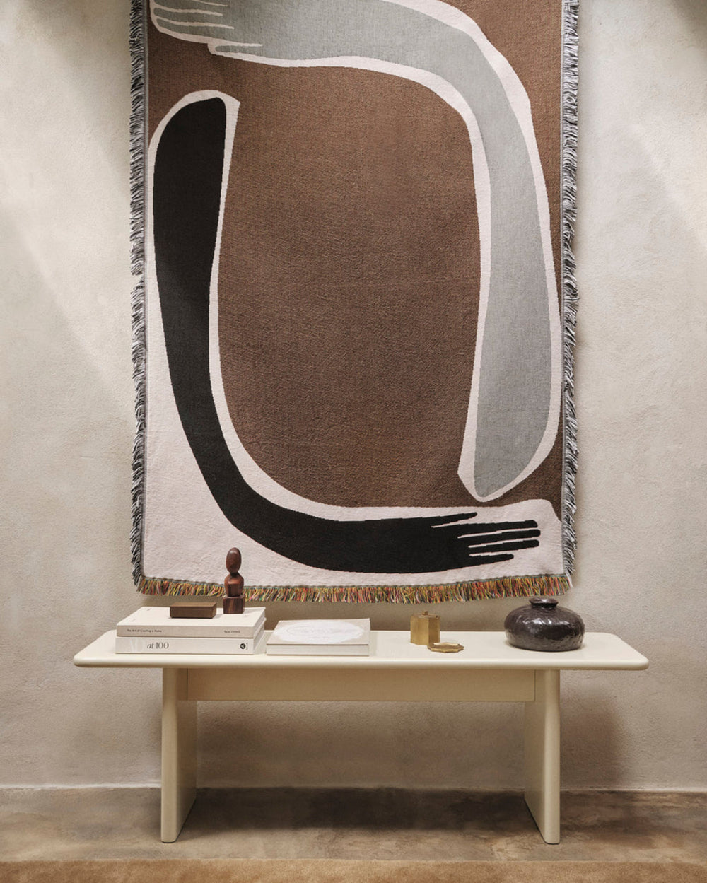 Pose Tapestry Blanket, Coffee by ferm LIVING, hanging above a console