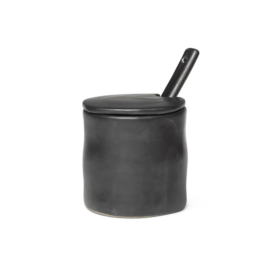 Black lidded jam jar with a spoon