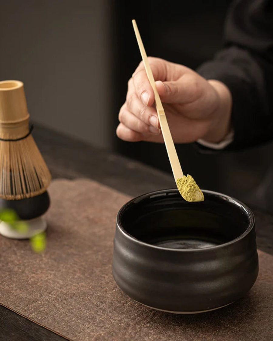 Ceramic Classic Matcha Set, Black by Gohobi, whisking matcha at a table