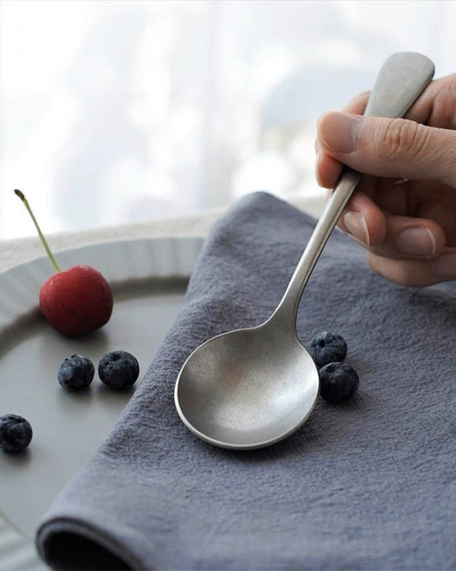 Stonewashed Stainless Steel Cutlery by Gohobi, with a cherry on a grey napkin