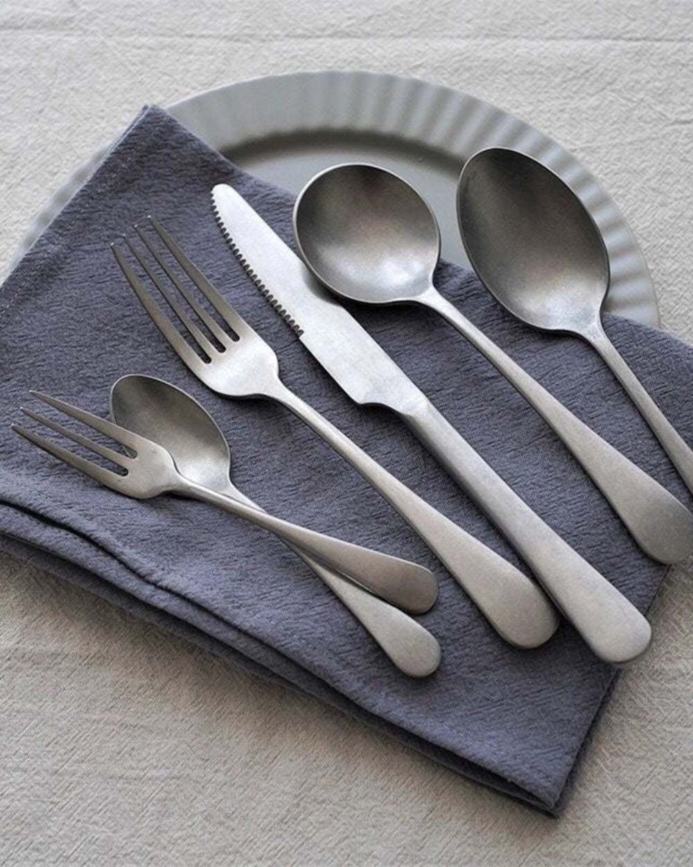 Stonewashed Stainless Steel Cutlery by Gohobi, on a grey napkin