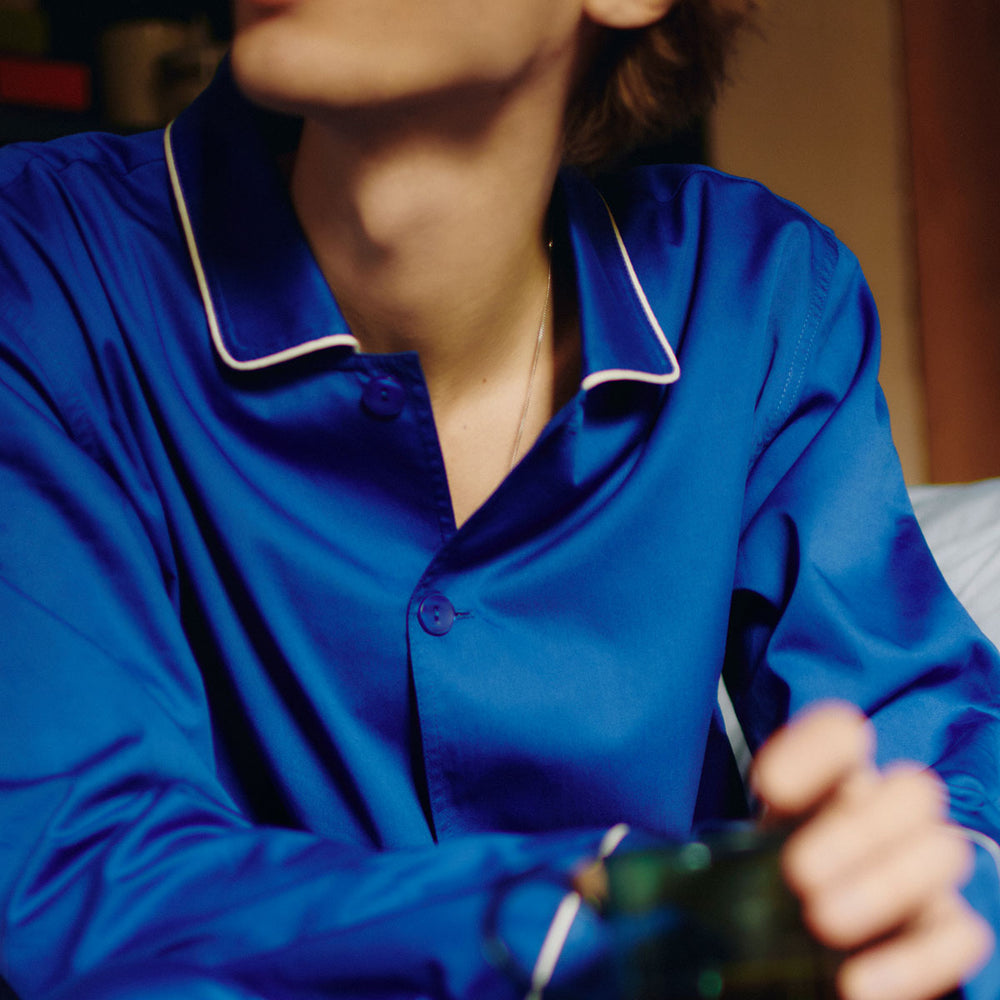 Outline Pyjama, Long Sleeve Shirt, Vivid Blue by HAY, worn by a man at a table