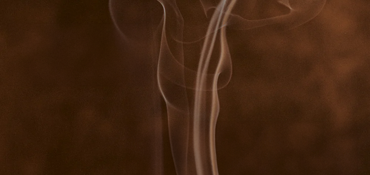Incense smoke against a dark brown background