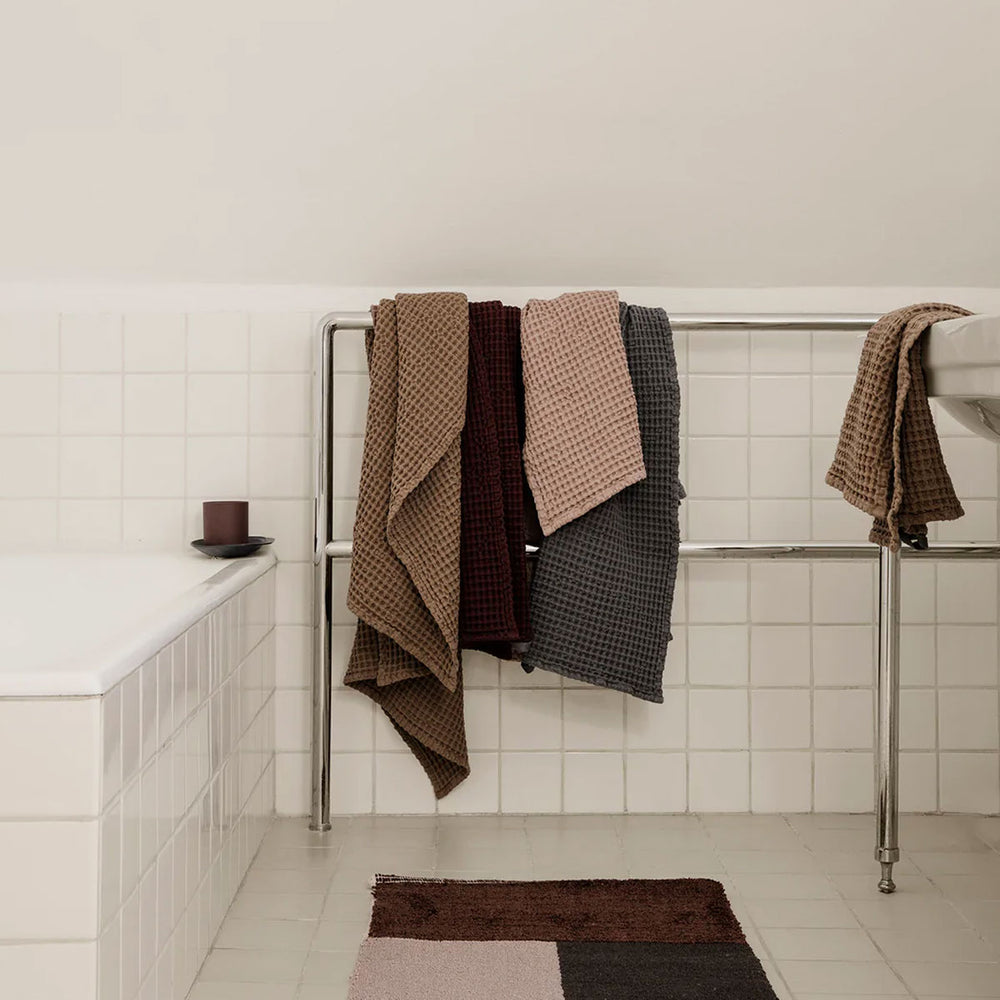 Organic Hand Towel, Off White by ferm LIVING, hanging in a bathroom