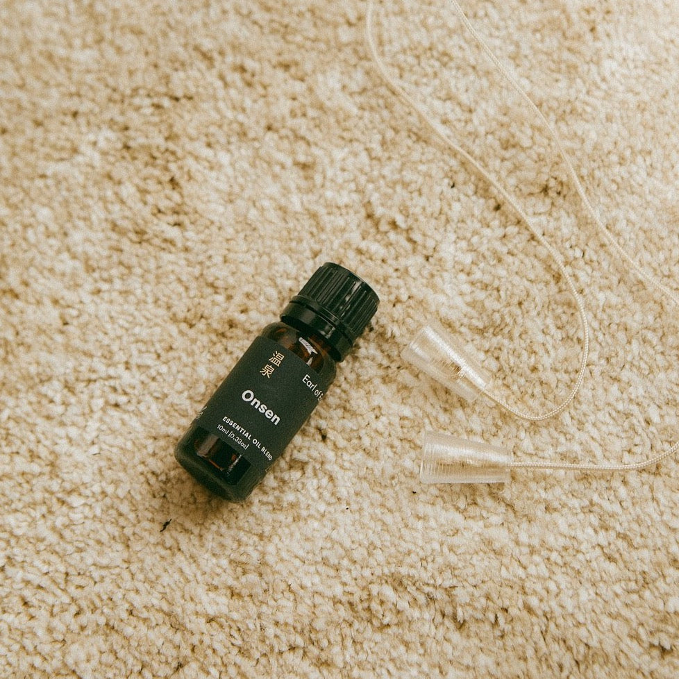 Onsen Essential Oil Blend, 10ml by Earl of East, on a cream rug