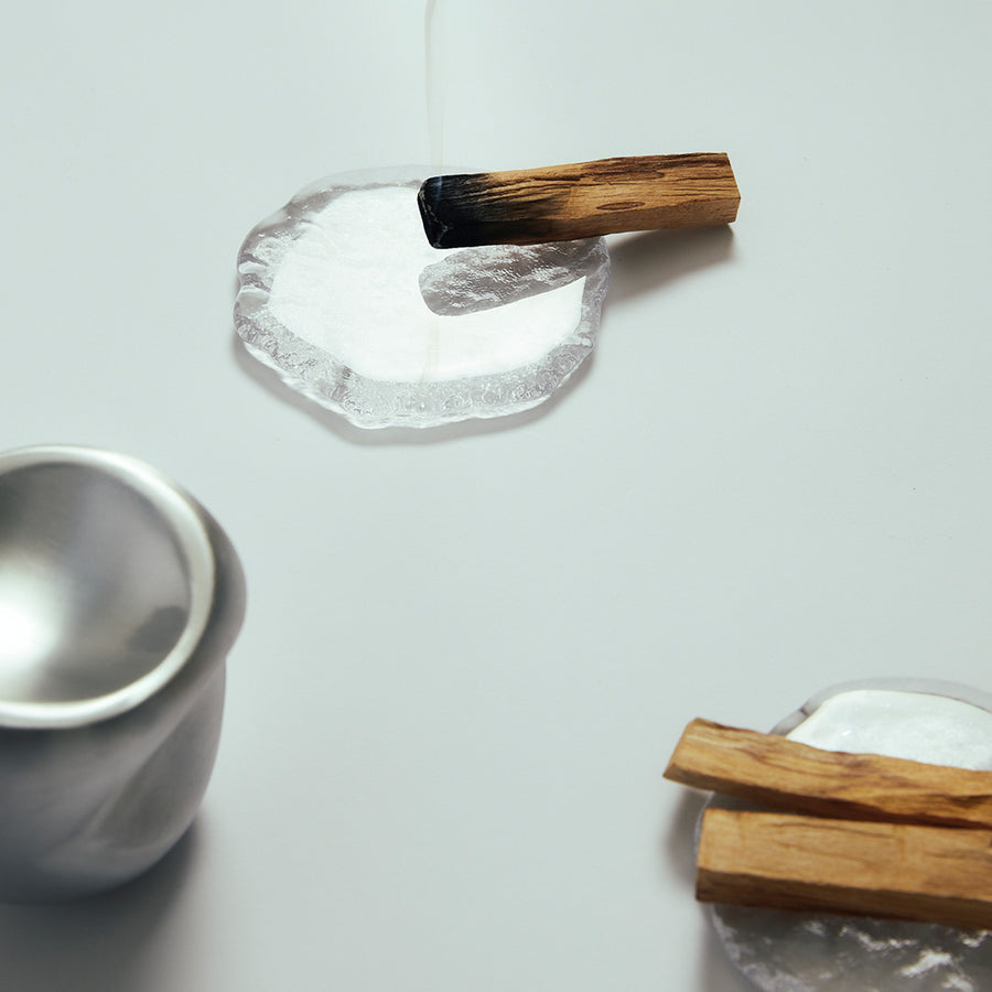 Palo Santo Stick by Earl of East, smouldering on a stone dish